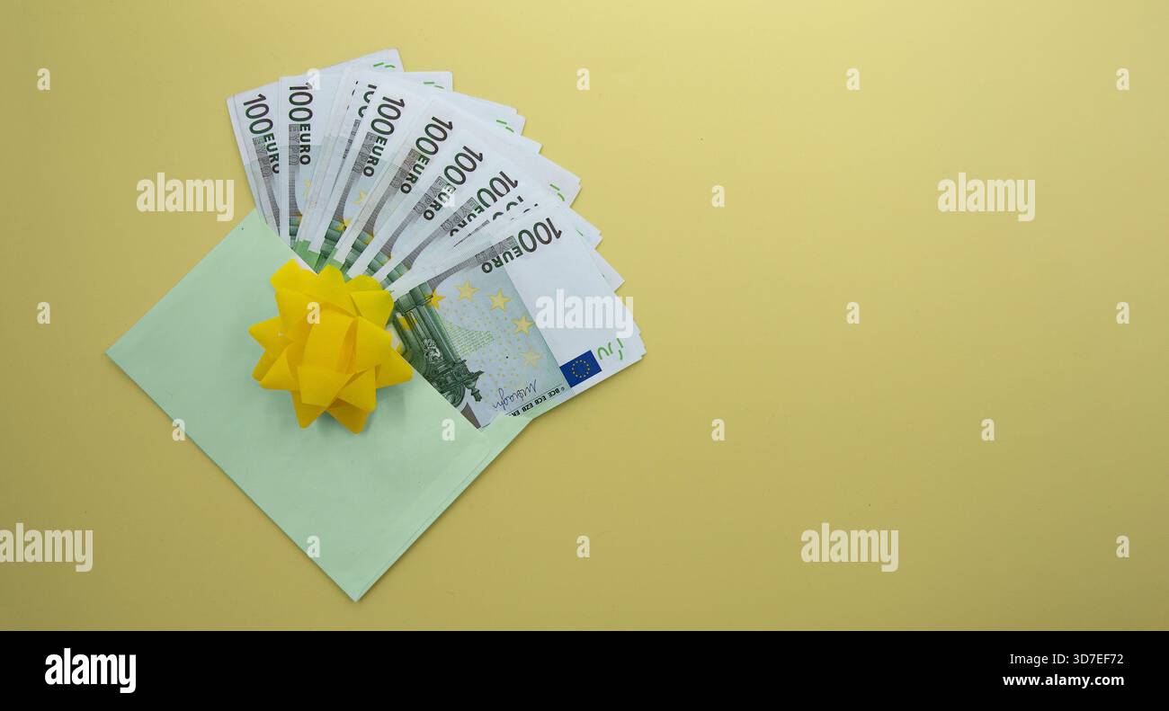 Busta regalo con banconote in euro e fiocco giallo brillante su sfondo pastello Foto Stock
