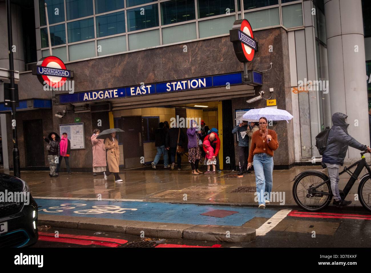 LONDRA - 29 OTTOBRE 2025: Aldgate East Station - iconica stazione della metropolitana di Londra e pendolari sotto la pioggia Foto Stock
