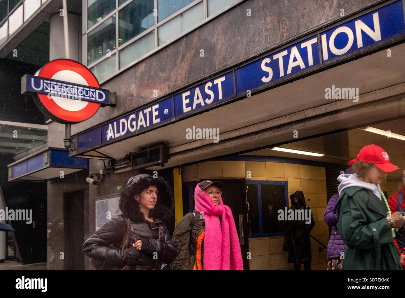 LONDRA - 29 OTTOBRE 2025: Aldgate East Station - iconica stazione della metropolitana di Londra e pendolari sotto la pioggia Foto Stock
