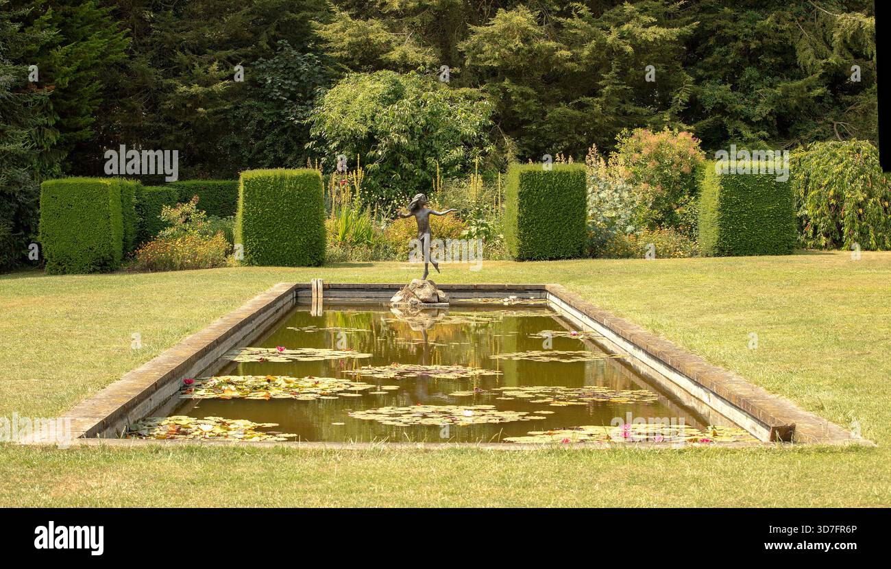 Waterperry, Oxford, Regno Unito. 9 luglio 2018. Laghetto rettangolare con statua in bronzo all'estremità Foto Stock