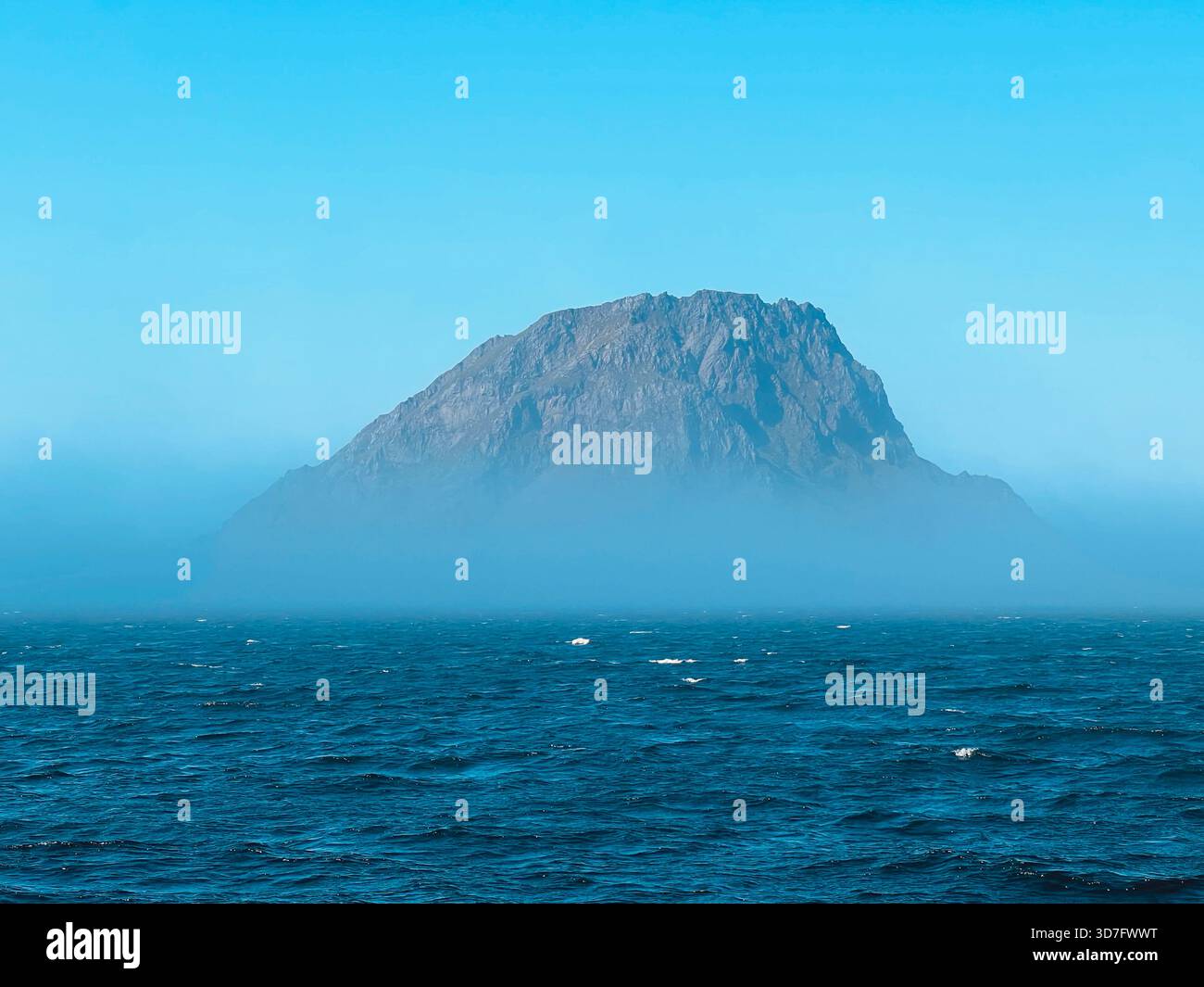 Isola rocciosa che sorge dal mare nebbioso al largo di sola sulla costa di Rogaland, Norvegia. - Immagine stock catturata con smartphone