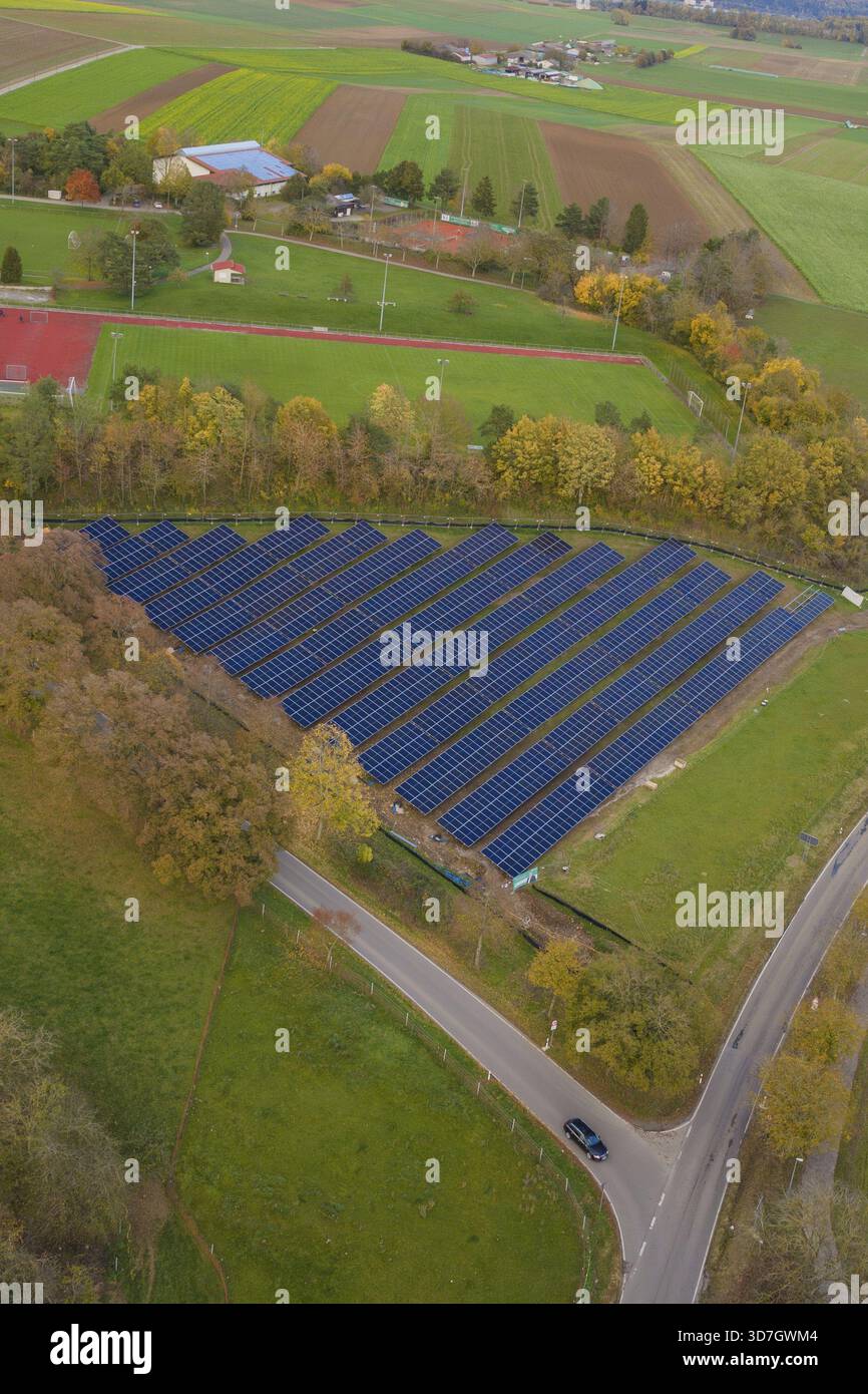 Sistemi solari incorporati in campi e alberi mostrati dall'aria durante l'autunno, Bau PV Freifaechenanlage, Weil der Stadt, Germania Foto Stock