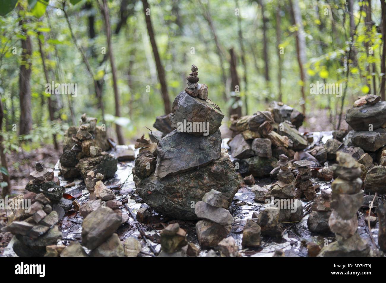 Calmo cairn di roccia zen che mostra equilibrio spirituale nella foresta verde. tranquilla pila di pietra che rappresenta armonia e serenità nella natura, meditativa all'aperto Foto Stock