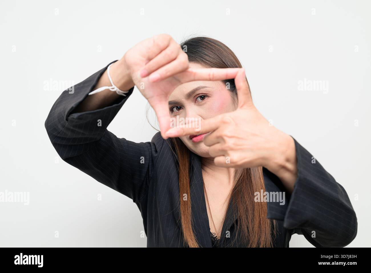 Ritratto in studio di una donna d'affari asiatica che indossa un blazer nero su sfondo bianco. Aspetto professionale e sicuro, adatto per aziende, Foto Stock