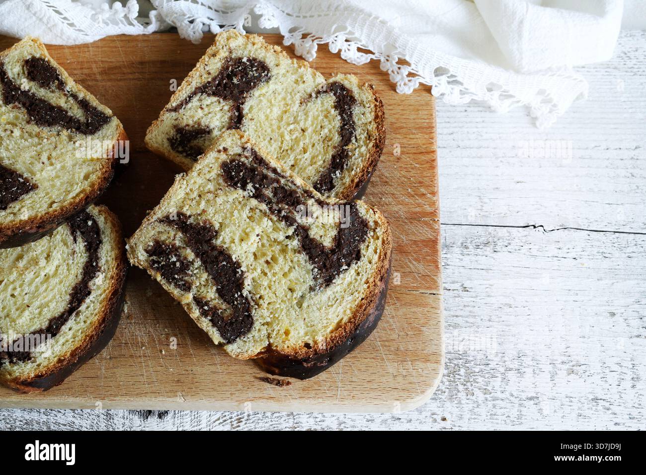 Cozonac, dolce tradizionale rumeno di Pasqua o di Natale. Tagliare il pane dolce su un tagliere di legno. Vacanze gastronomiche dell'Europa orientale. Foto Stock