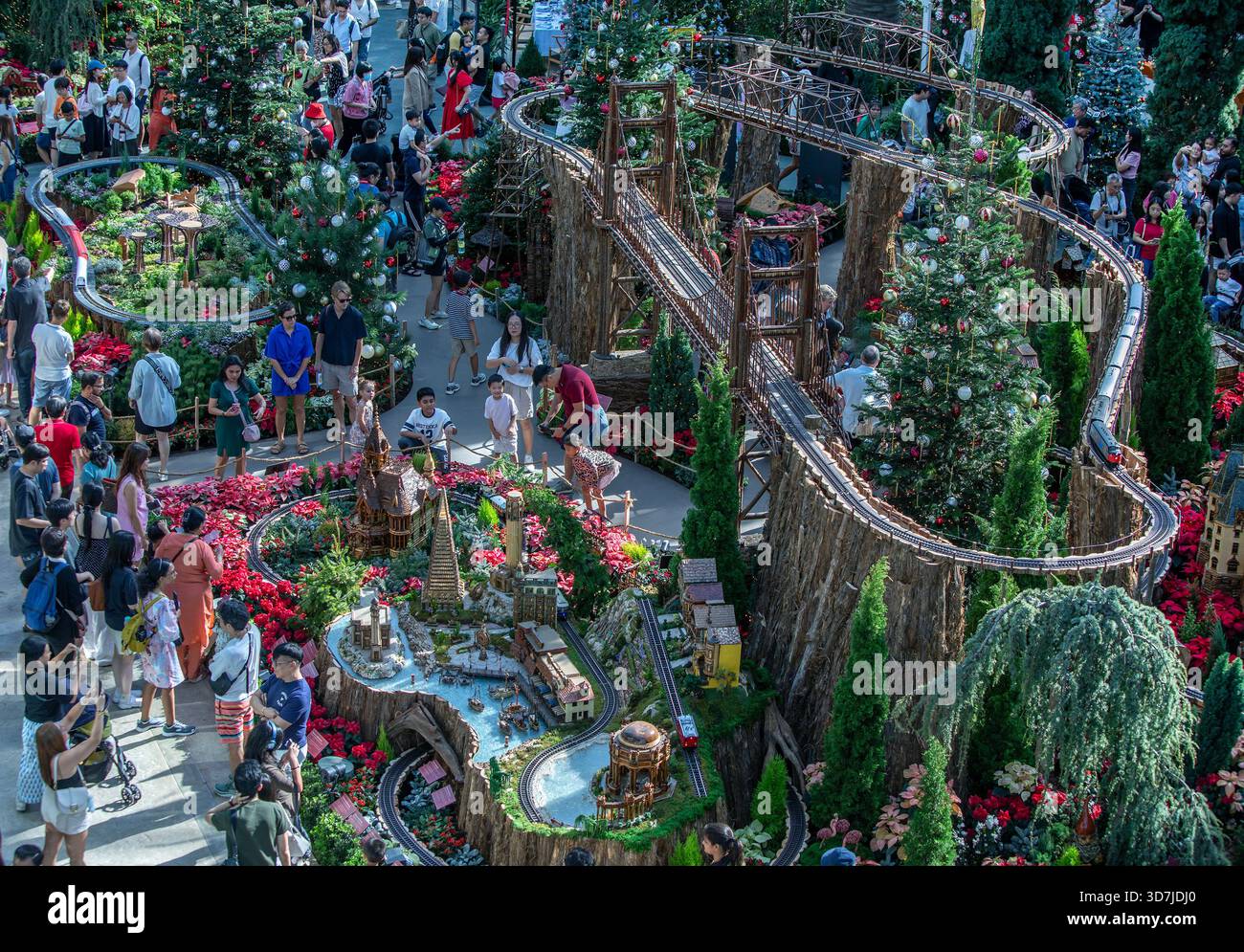 Una folla di persone vedrà diversi set di modellini di treni che formano lo spettacolo natalizio all'interno della Flower Dome presso Gardens by the Bay di Singapore. Foto Stock