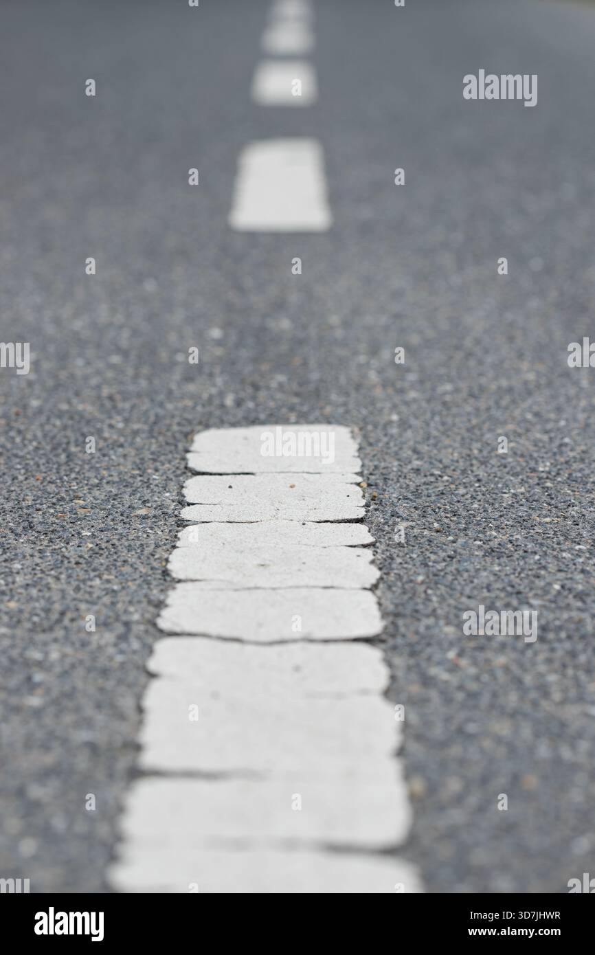Sfondo asfalto verticale con linee tratteggiate bianche sulla strada che conduce in avanti verso il futuro Foto Stock