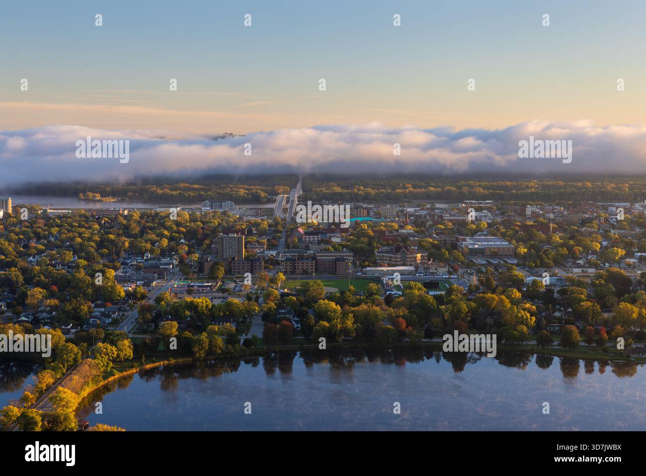 Una vista panoramica di una città lungo il fiume Mississippi con un lago in primo piano e nuvole di nebbia all'orizzonte. Foto Stock