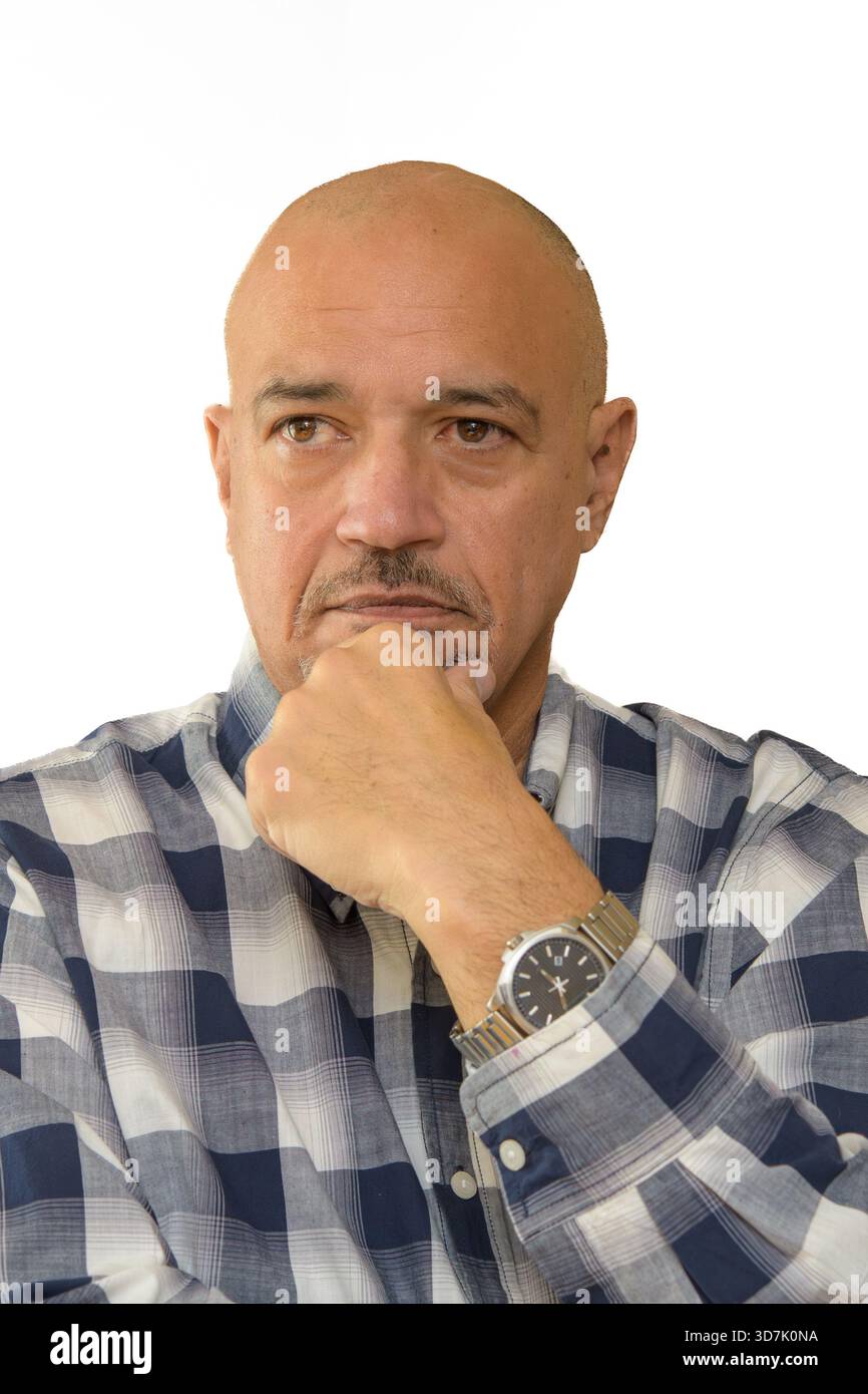 Uomo calvo che poggia il mento sulla mano in una posa ponderata su uno sfondo neutrale. Foto Stock