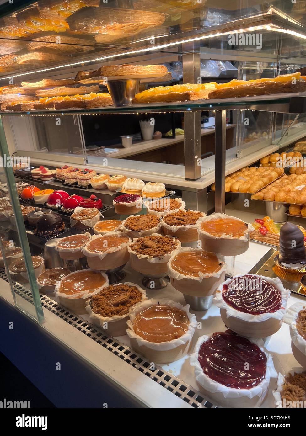 Negozio di pasticceria a Madrid, Spagna, pieno di torte colorate, crostate e dolci tradizionali dietro un banco di vetro. Foto Stock