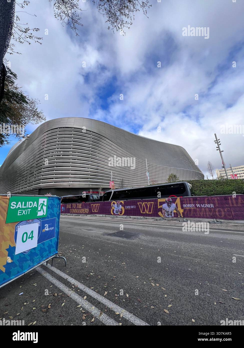 Stadio Santiago Bernabéu a Madrid, Spagna, con barriere agli eventi e striscioni NFL fuori dalla moderna arena sotto nuvole spettacolari. Foto Stock