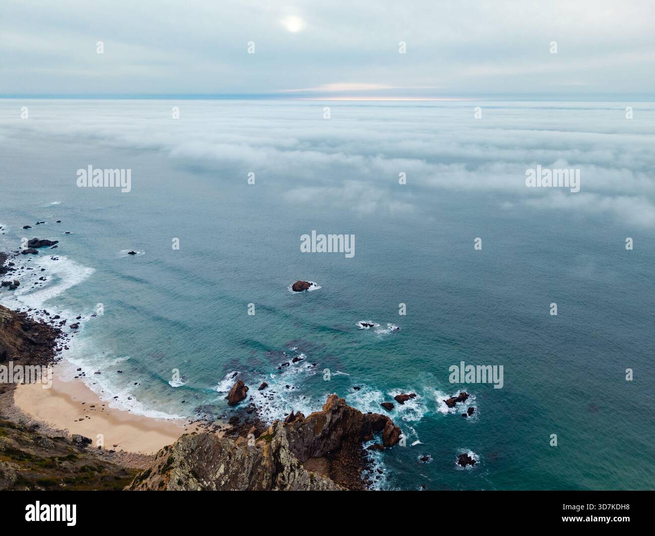 Splendida fotografia aerea che cattura una spiaggia di sabbia isolata e formazioni rocciose frastagliate lungo la costa di Cabo da Roca, Portogallo Foto Stock