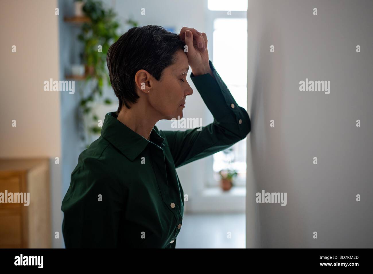 Donna matura stanca e senza speranza appoggiata al muro in lotta mentale e profonda crisi personale. Esaurimento emotivo, difficoltà schiaccianti, problemi di salute mentale, sofferenza turbolenta, dolore e intrappolato || modello rilasciato Foto Stock