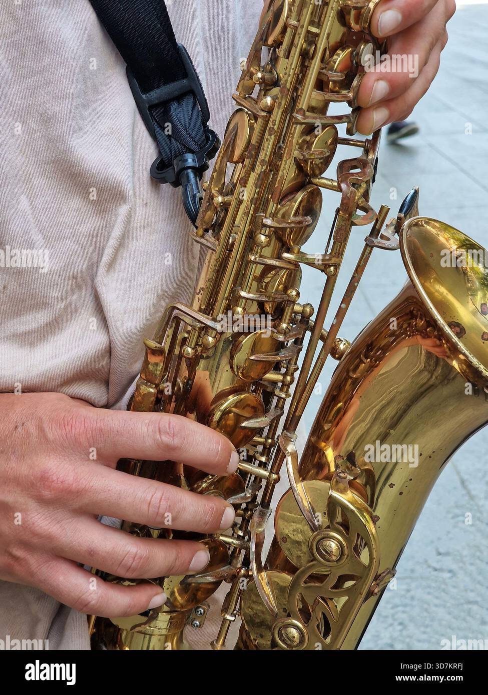Primo piano immagine verticale della mano del musicista che suona note su un sassofono dorato. Foto Stock