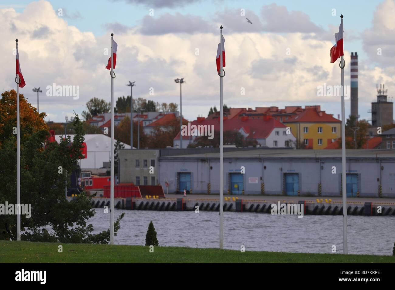 Bandiere polacche che sventolano accanto a un porto industriale sul lungomare Foto Stock