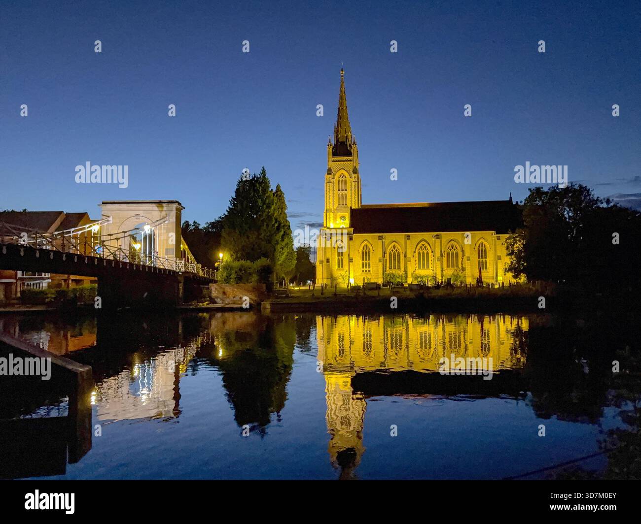 Marlow, Buckinghamshire, Inghilterra, Regno Unito - 20 luglio 2025: Vista panoramica della Chiesa di tutti i Santi lungo il ponte a catena di Marlow con una riflessione nel Ri Foto Stock
