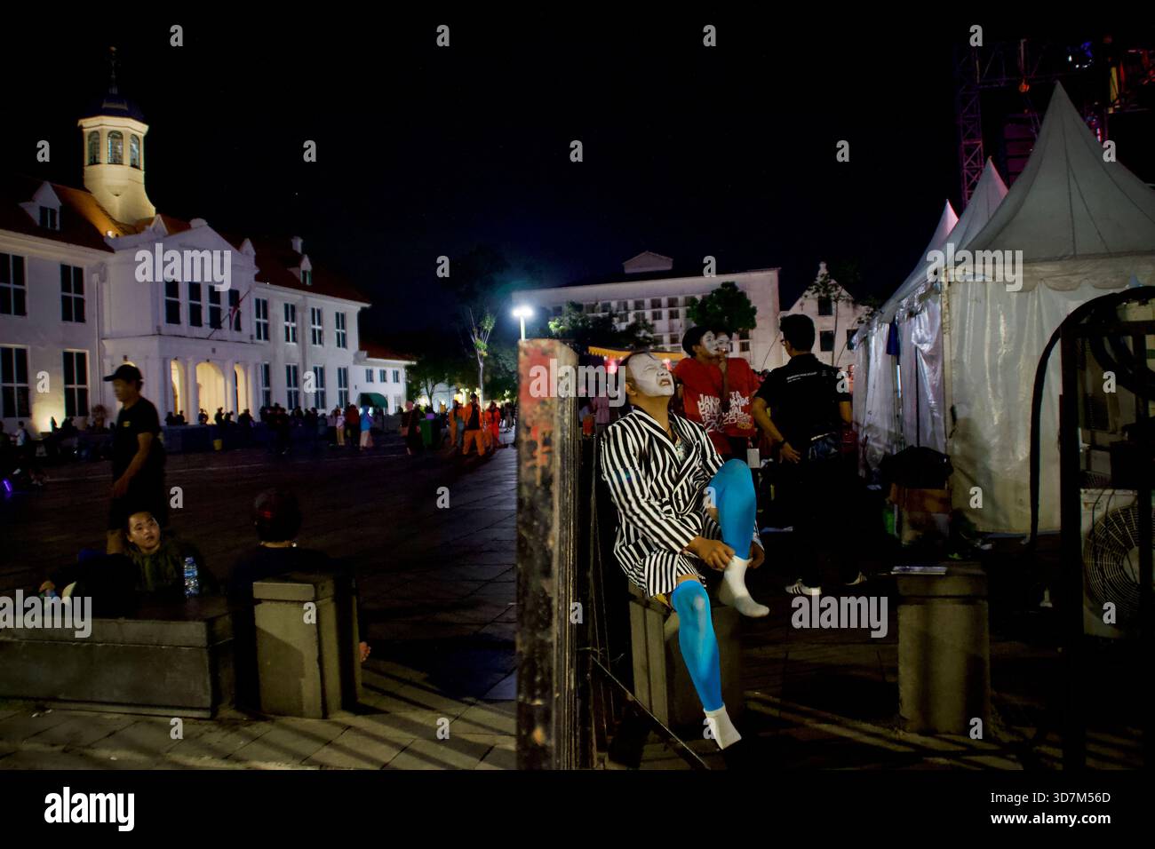 Un mimo si prepara dietro le quinte con un costume a righe al Fatahillah Heritage Park prima di esibirsi sul palco al Jakarta Pantomime Festival del 2025 Foto Stock