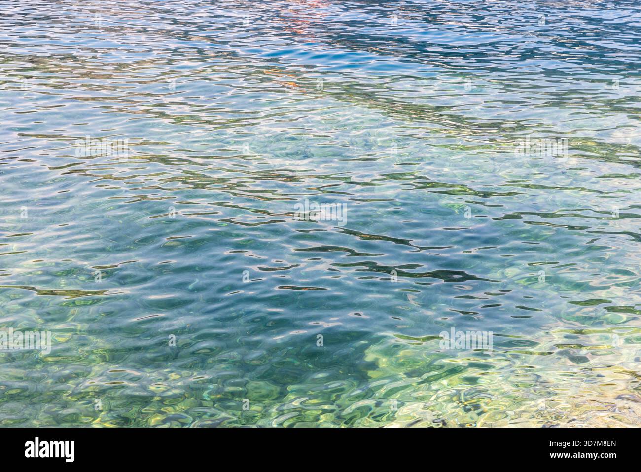 Superficie di acqua marina vibrante con riflessi colorati sulle onde morbide. Sfondo ideale per viaggi, natura e scene di sfondo. Foto di sfondo naturale Foto Stock