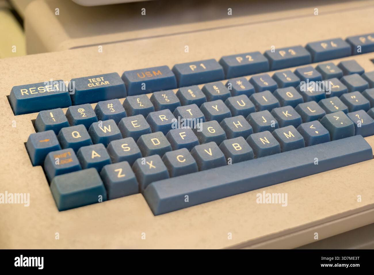 Primo piano su una vecchia tastiera per computer in stile retrò polveroso, spessi tasti blu vintage delle apparecchiature per PC degli anni '80 degli anni '90, tecnologia informatica obsoleta, qw classico Foto Stock