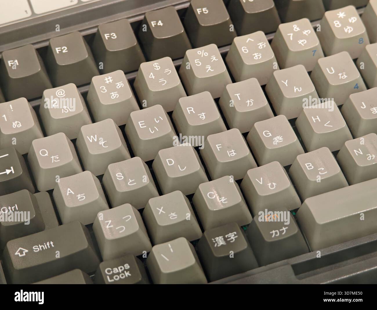 Tastiera in lingua giapponese rétro con hiragana katakana e lettere latine tappi per PC grigio vintage dettaglio dettaglio layout qwerty, caratteri stranieri e. Foto Stock