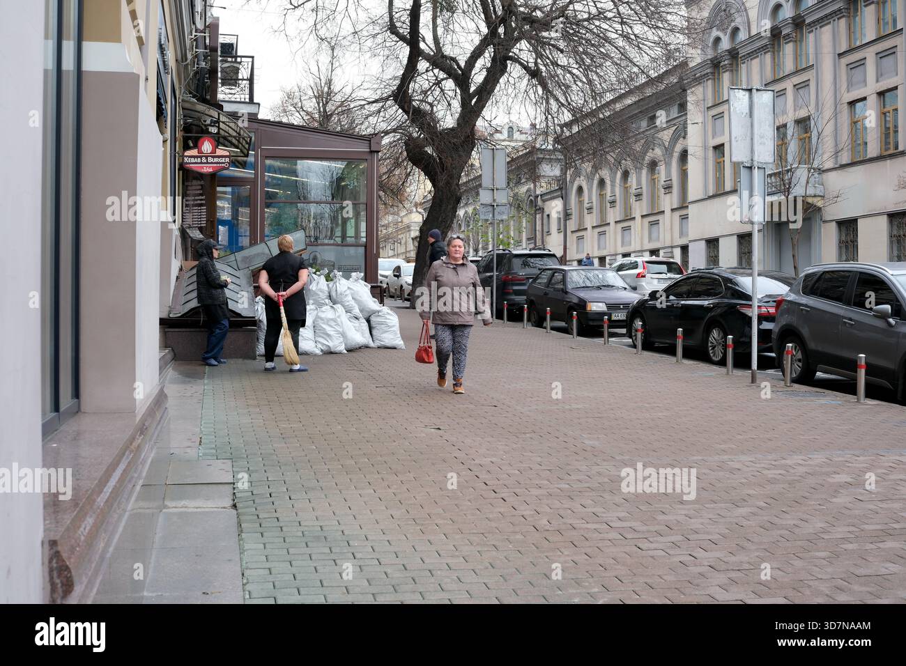 La vita cittadina si sviluppa mentre i pedoni passeggiano lungo un'affascinante strada acciottolata. Kiev, Ucraina, 26 novembre 2025. Foto Stock