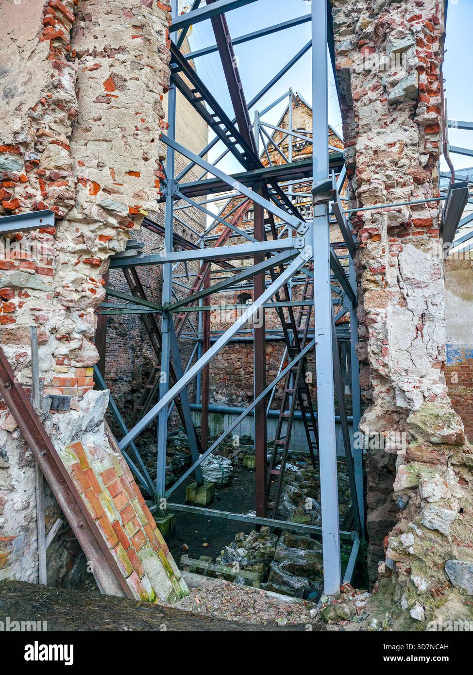 Vista delle vecchie rovine in mattoni sostenute da travi d'acciaio durante i lavori di conservazione a riga, Lettonia, evidenziando il decadimento architettonico e gli sforzi di restauro Foto Stock