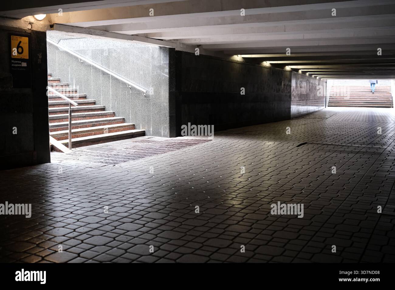 Un tranquillo sentiero sotterraneo presenta scale che si innalzano verso la luce del giorno. Foto Stock