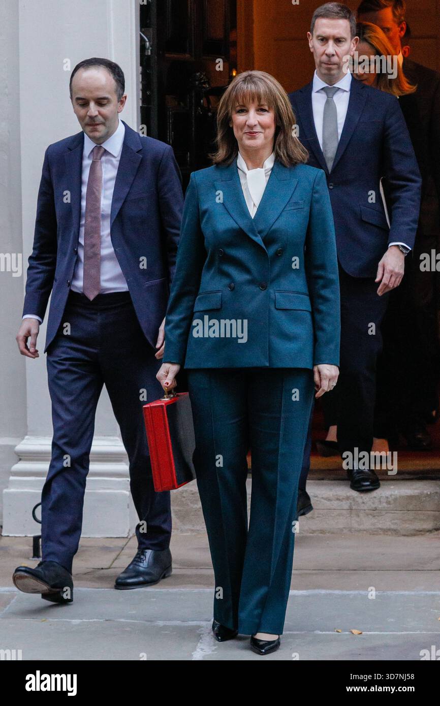 Londra, Regno Unito. 26 novembre 2025. Reeves con il suo team del Tesoro, qui James Murray (a sinistra) e Lord Livermore (a destra) Rachel Reeves, Cancelliere dello Scacchiere del Regno Unito, presenta la "cassa di bilancio" rossa, la sua scatola di spedizione ministeriale, alla stampa in attesa fuori 11 Downing Street. La sua squadra del Tesoro esce con lei. Poi si reca in Parlamento per presentare la sua attesissima dichiarazione di bilancio per l'autunno. Crediti: Imageplotter/Alamy Live News Foto Stock