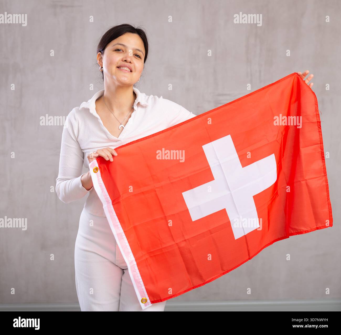 Giovane donna in posa in studio con bandiera svizzera Foto Stock