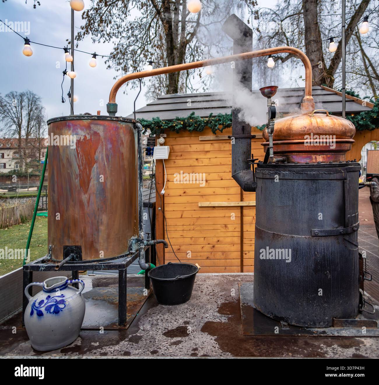 Lavorare in alambicco tradizionale in rame o in pentola ancora distillando brandy alla frutta o eau de vie, lievitazione del vapore, in un mercatino di Natale a Strasburgo, in Francia Foto Stock