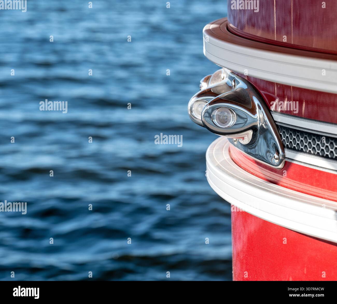 Luce in acciaio inossidabile sull'angolo anteriore di un pontone rosso che si sposta su un lago. Foto Stock