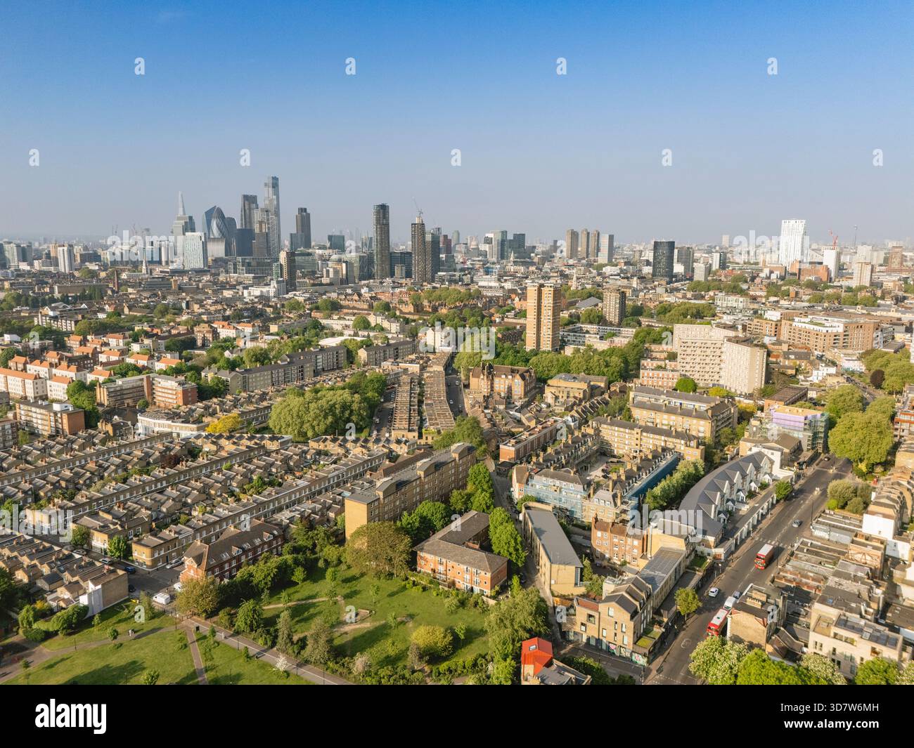 Veduta aerea di un vasto paesaggio urbano con grattacieli e spazi verdi sotto un cielo azzurro. Londra, Regno Unito Foto Stock