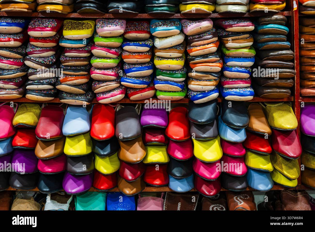 Le colorate pantofole in pelle marocchina sovrapposte sono esposte in una vivace banchina del mercato. Fez, Fez-Meknes, Marocco settentrionale Foto Stock