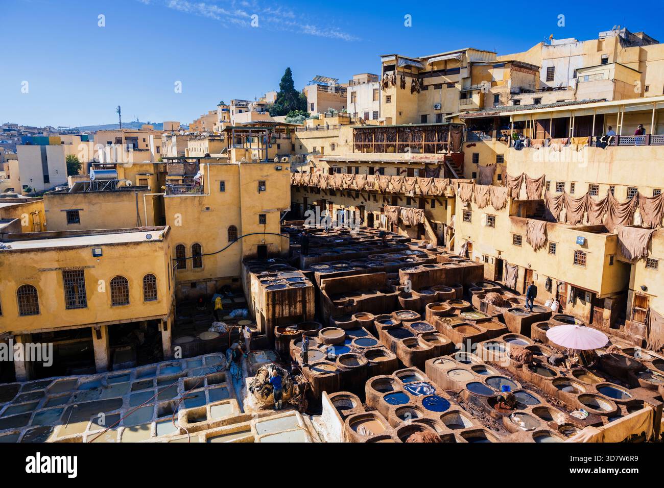 Antiche concerie in pelle con edifici sotto un cielo azzurro e limpido in un paesaggio urbano mediorientale. Fez, Fez-Meknes, Marocco settentrionale Foto Stock