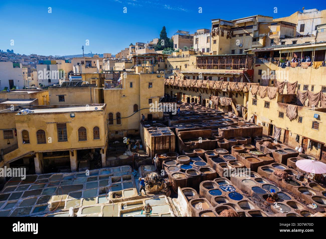 Antiche concerie in pelle con edifici sotto un cielo azzurro e limpido in un paesaggio urbano mediorientale. Fez, Fez-Meknes, Marocco settentrionale Foto Stock
