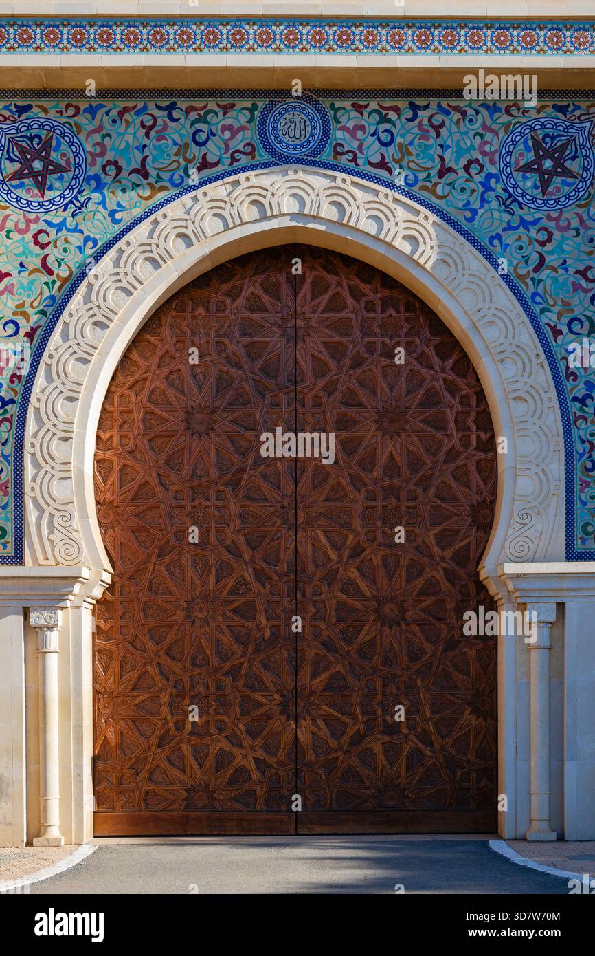 Porta in legno decorata in un intricato arco con vivaci piastrelle a mosaico. Fez, Fez-Meknes, Marocco settentrionale Foto Stock