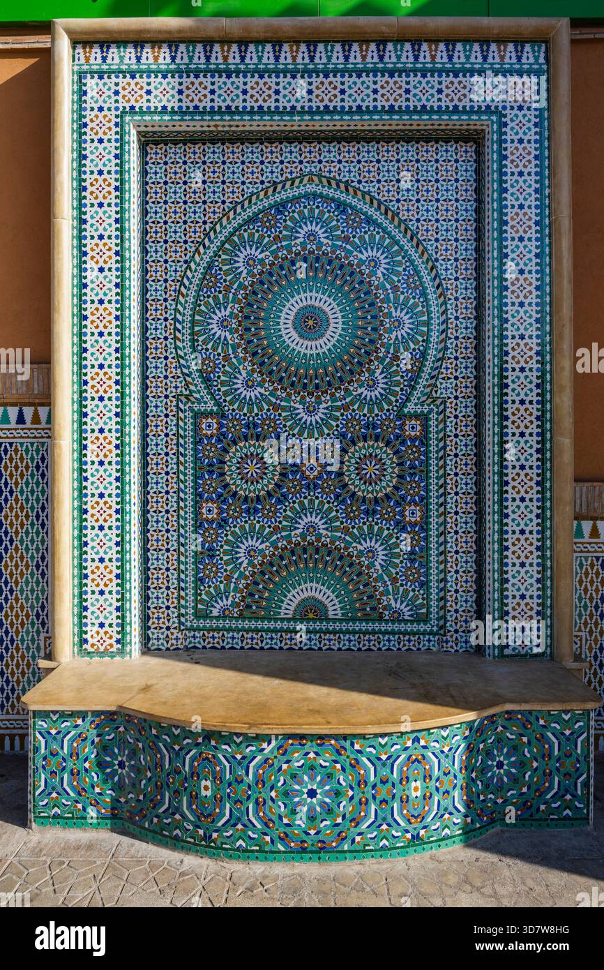 Fontana a mosaico decorata con intricati motivi geometrici e colori vivaci in uno stile tradizionale. Marrakech, Marocco Foto Stock