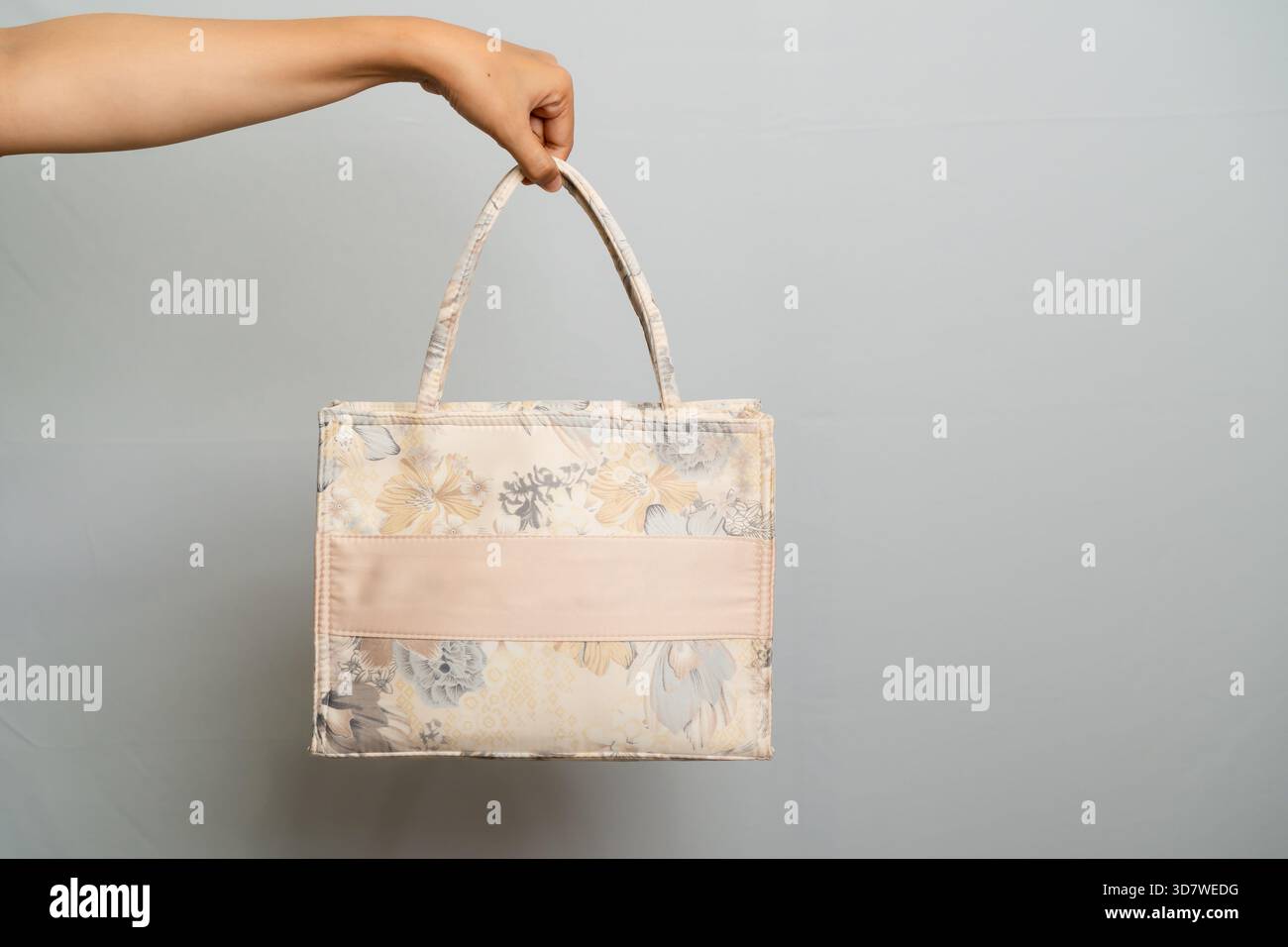 Borsa tote ricamata con motivo floreale e nastro satinato isolato su grigio Foto Stock