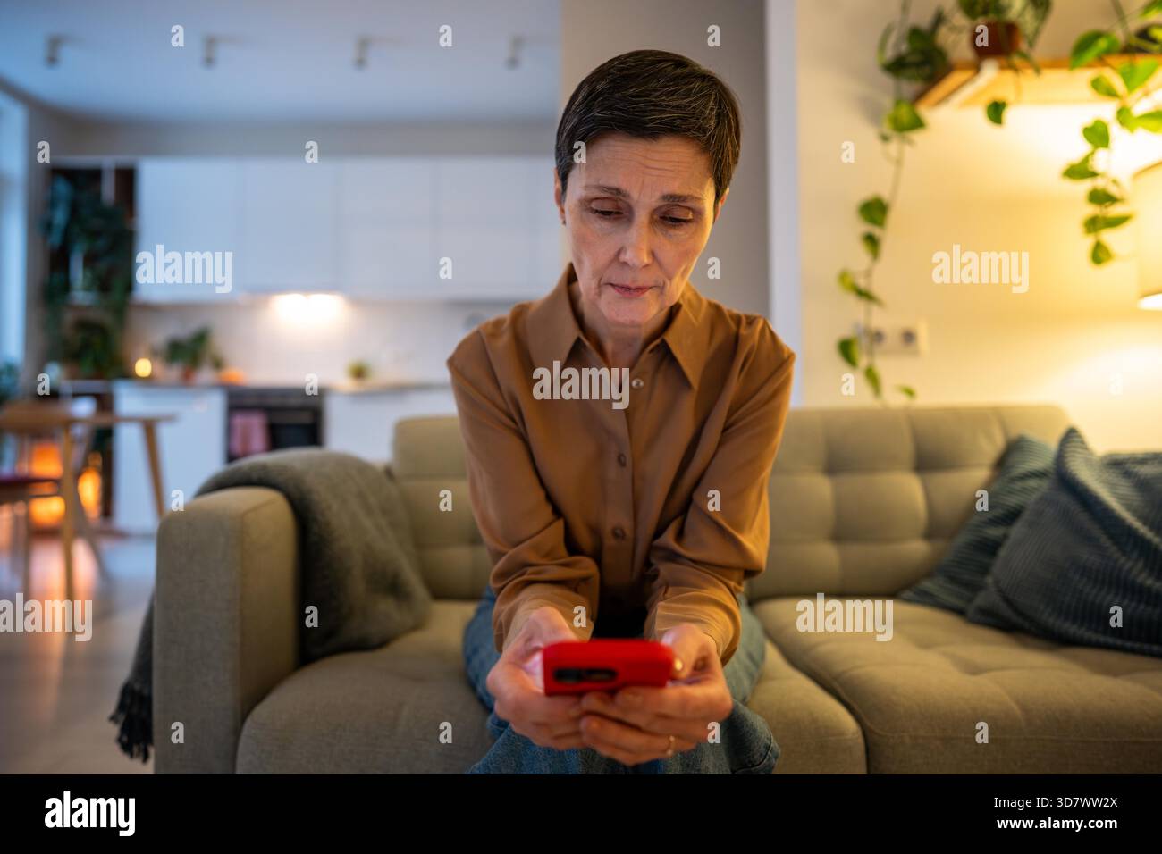 Donna sola preoccupata stanca e disimpegnata, in attesa di aggiornamenti che controllino il telefono per i messaggi di famiglia, la consegna o le notizie a casa. Sentirsi isolati, disconnessi dal mondo, stanchezza emotiva. || modello rilasciato Foto Stock