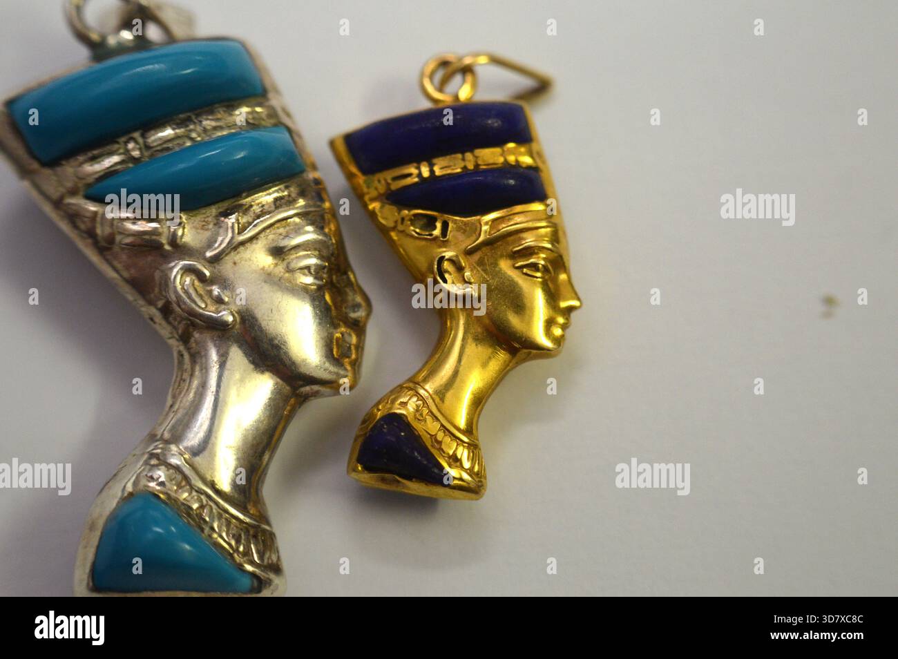 Ciondoli d'oro e d'argento raffiguranti il busto della regina Nefertiti, moglie del faraone Akhenaton, durante la XVIII dinastia, il suo nome significa (il Beautifu Foto Stock