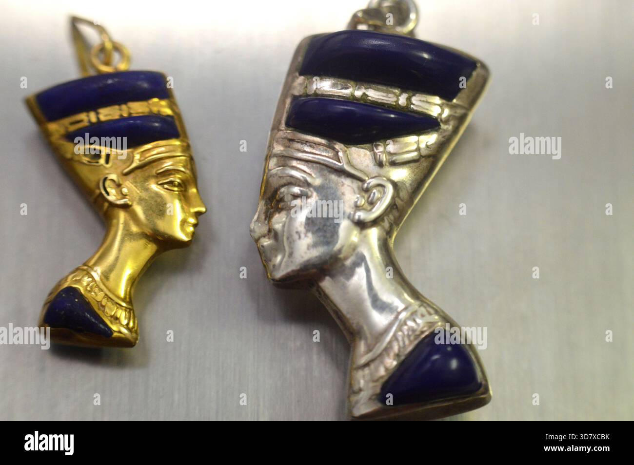 Ciondoli d'oro e d'argento raffiguranti il busto della regina Nefertiti, moglie del faraone Akhenaton, durante la XVIII dinastia, il suo nome significa (il Beautifu Foto Stock