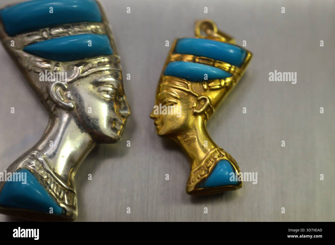 Ciondoli d'oro e d'argento raffiguranti il busto della regina Nefertiti, moglie del faraone Akhenaton, durante la XVIII dinastia, il suo nome significa (il Beautifu Foto Stock