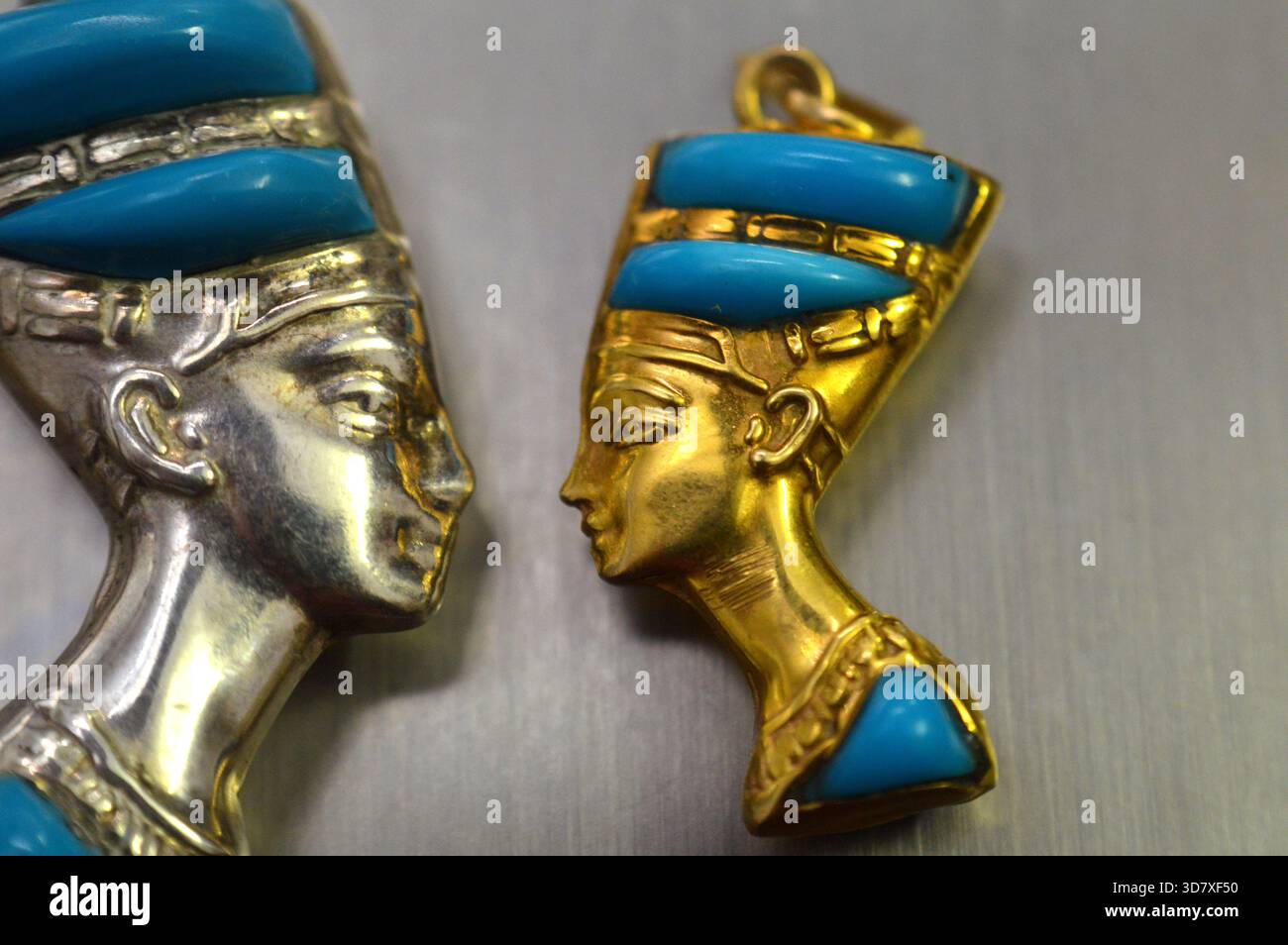 Ciondoli d'oro e d'argento raffiguranti il busto della regina Nefertiti, moglie del faraone Akhenaton, durante la XVIII dinastia, il suo nome significa (il Beautifu Foto Stock