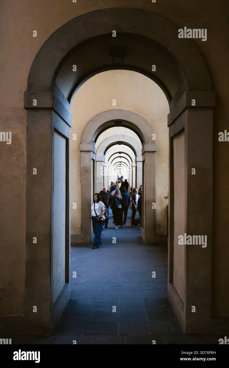 I turisti camminano attraverso i portici del corridoio Vasariano sul Ponte Vecchio, Firenze, Toscana, Italia Foto Stock