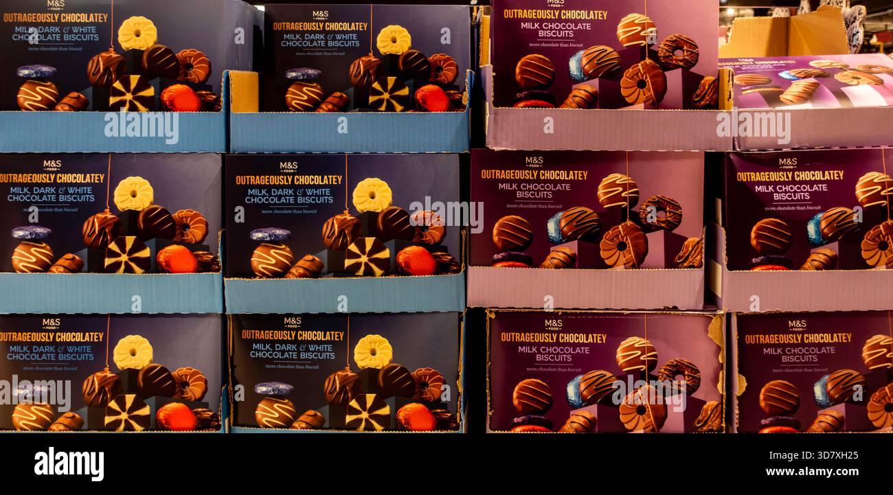 M&S (Marks & Spencer) "Otrageously Chocolatey", biscotti al cioccolato fondente e bianco sono mostrati in un'enorme esposizione al dettaglio sovrapposta. Foto Stock