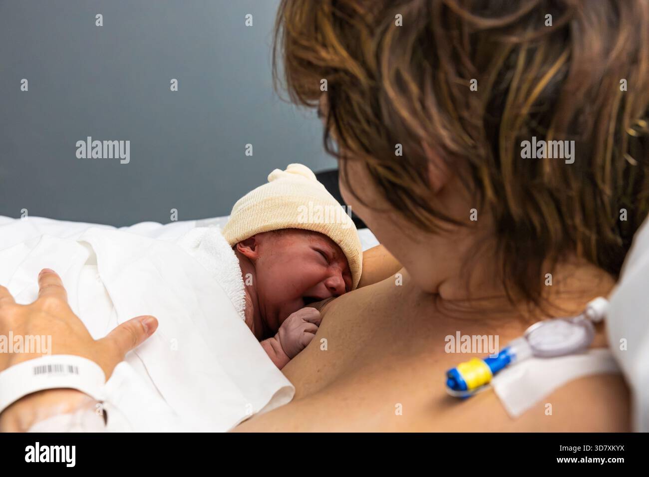 Madre che soffre di contatto pelle-pelle con neonato che piange Foto Stock