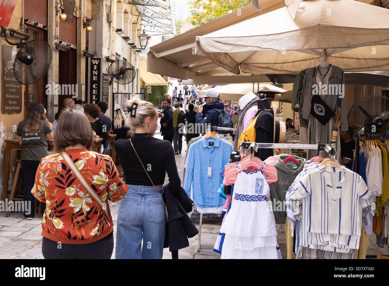 Athens Plaka Street; persone che fanno acquisti di vestiti nelle strade della zona di Plaka, popolare tra i turisti, Atene Grecia Europa Foto Stock