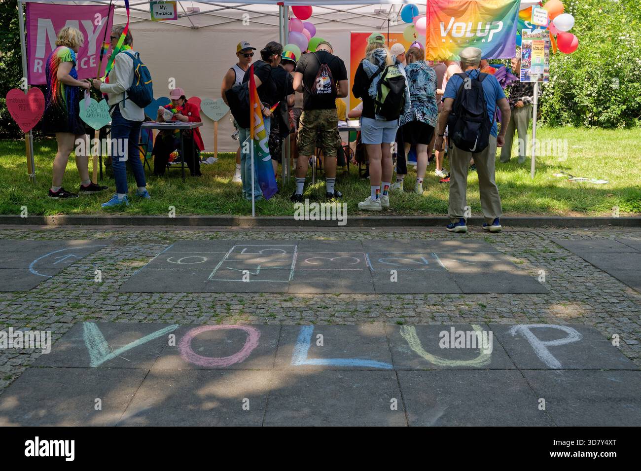 Le persone si riunirono in una tenda VOLUP con disegni di gesso sul marciapiede durante il Pride di Varsavia (Parada Równości). Foto Stock
