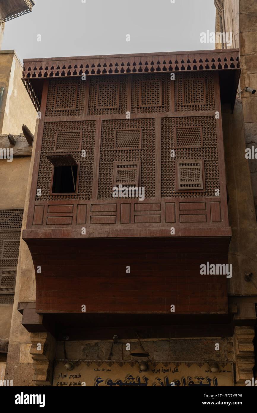 Un mashrabiyya in legno fornisce ombra, ventilazione e discrezione ad una casa tradizionale nel medioevo, storico Cairo, Egitto. Foto Stock