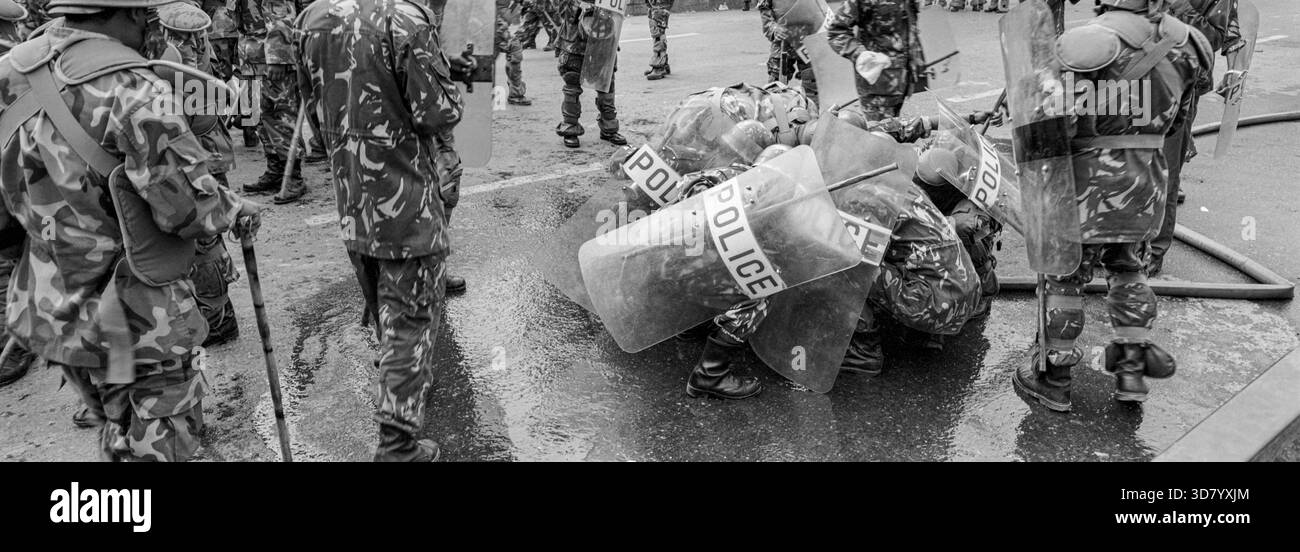 Durante le dimostrazioni in corso nel 2003 Kathmandu, ci sono stati molti scontri tra polizia e pubblico, qui la polizia si riprende da un attacco di gas lacrimogeni Foto Stock